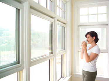 Woman looking out window drinking coffee